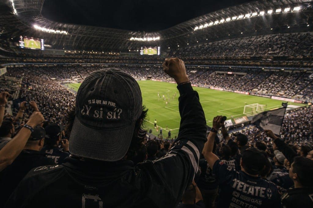 Gorra ¿Y si sí? negra en un estadio lleno de afición